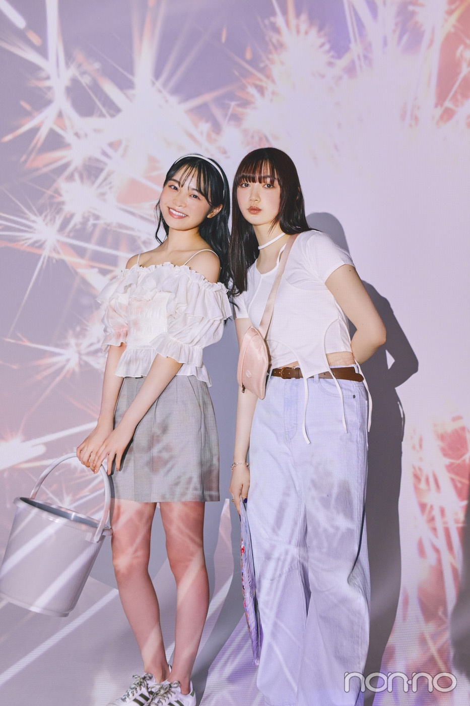 花火の写真の前に立つ林芽亜里と小宮山莉渚