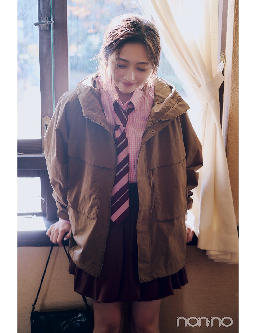 最高気温20度の日のアウター　ブラウンのフード付きジャケットを着ている女性