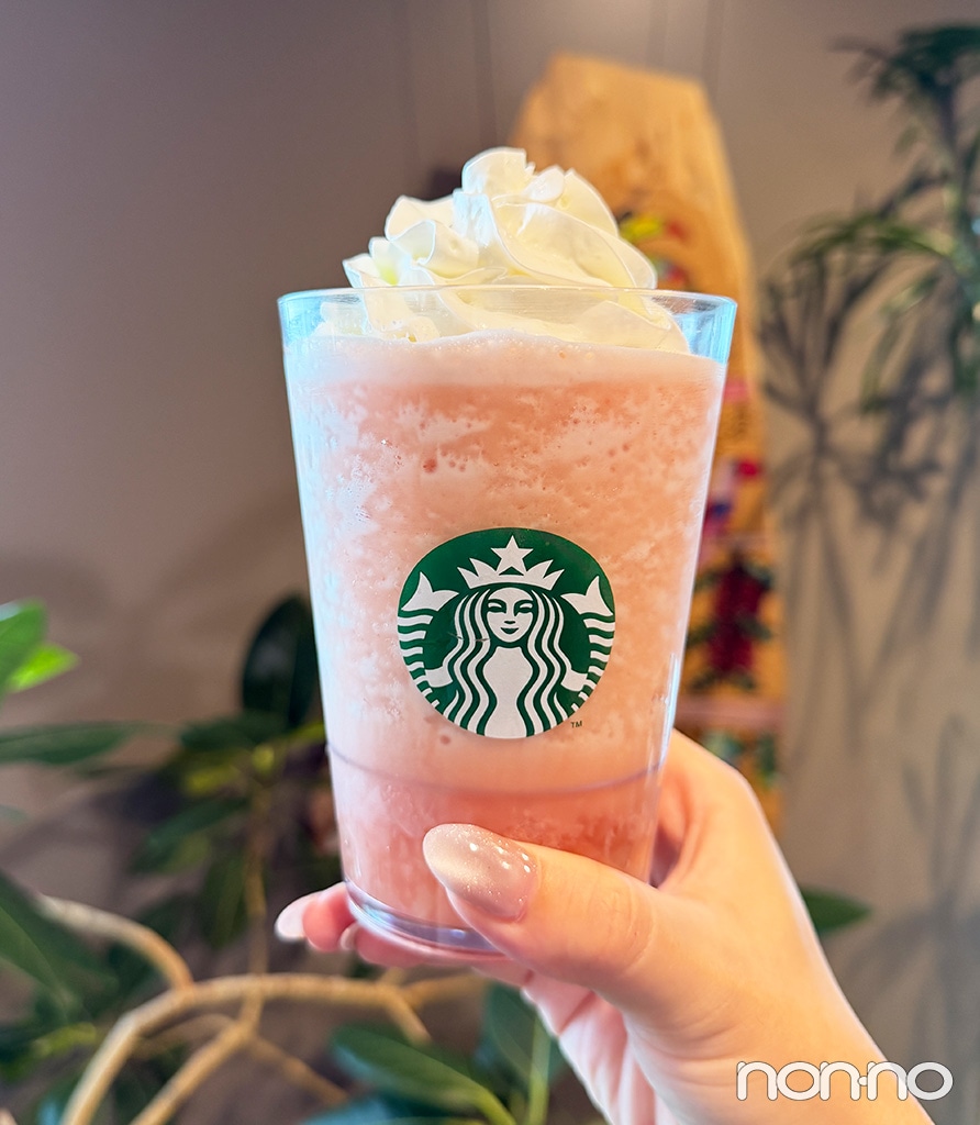 『ピーチ & ピーチミルク フラペチーノ®』を手に持っている様子