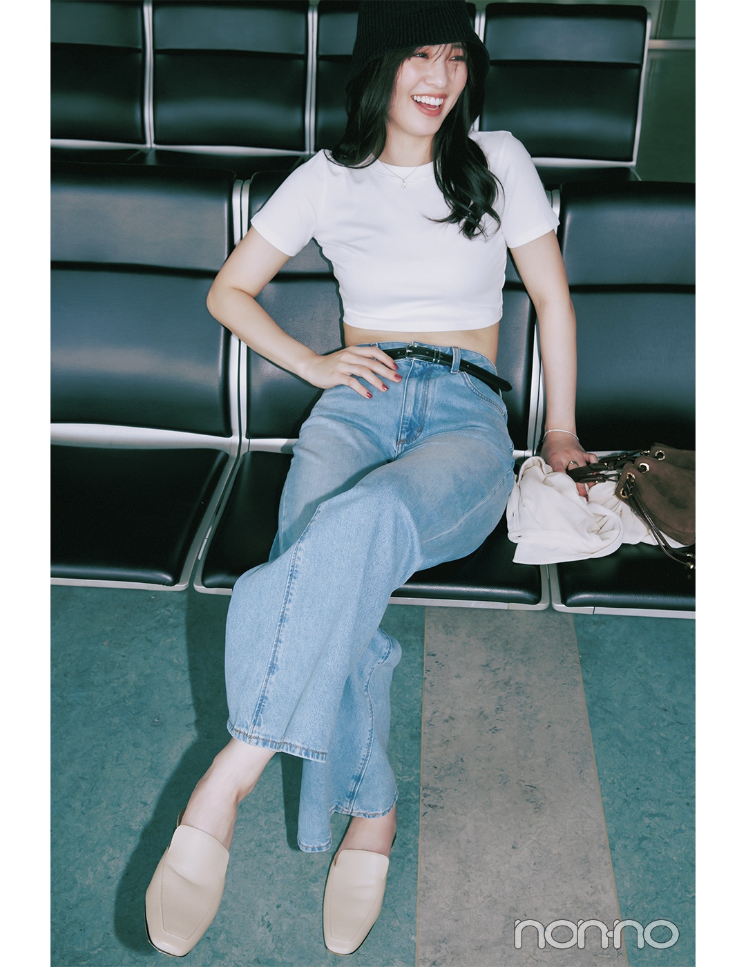 白Tシャツ×デニムパンツコーデで座っている女性