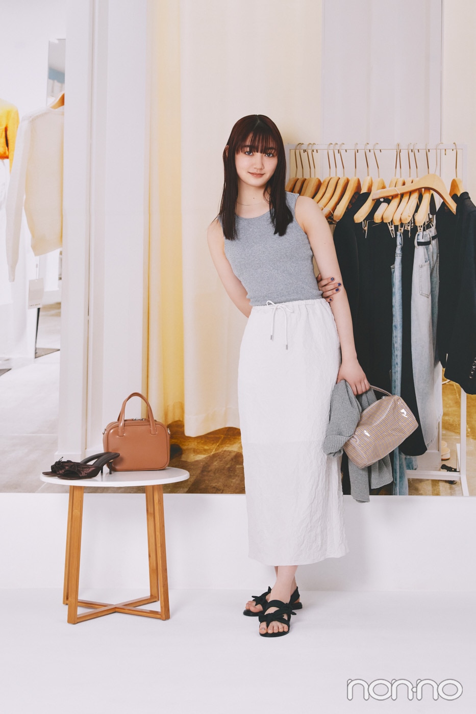 グレーのタンクに白のスカートを着た小宮山莉渚