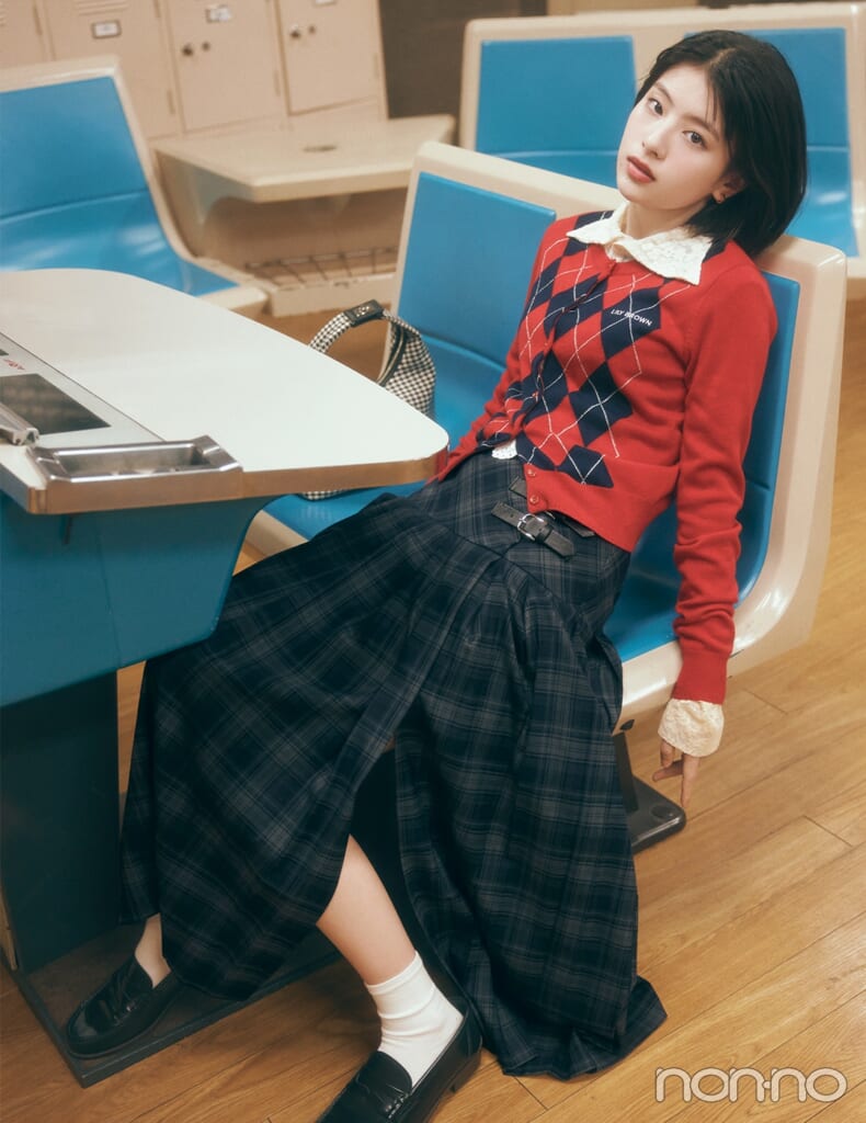 赤ニットカーディガンとチェック柄スカートを合わせた赤ニットコーデの女性