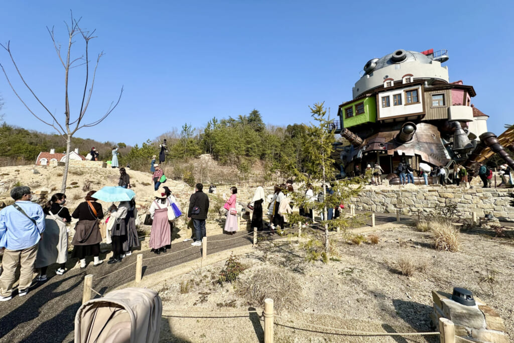 カブのカカシと「ハウルの城」を背景に写真を撮りたい人々の行列