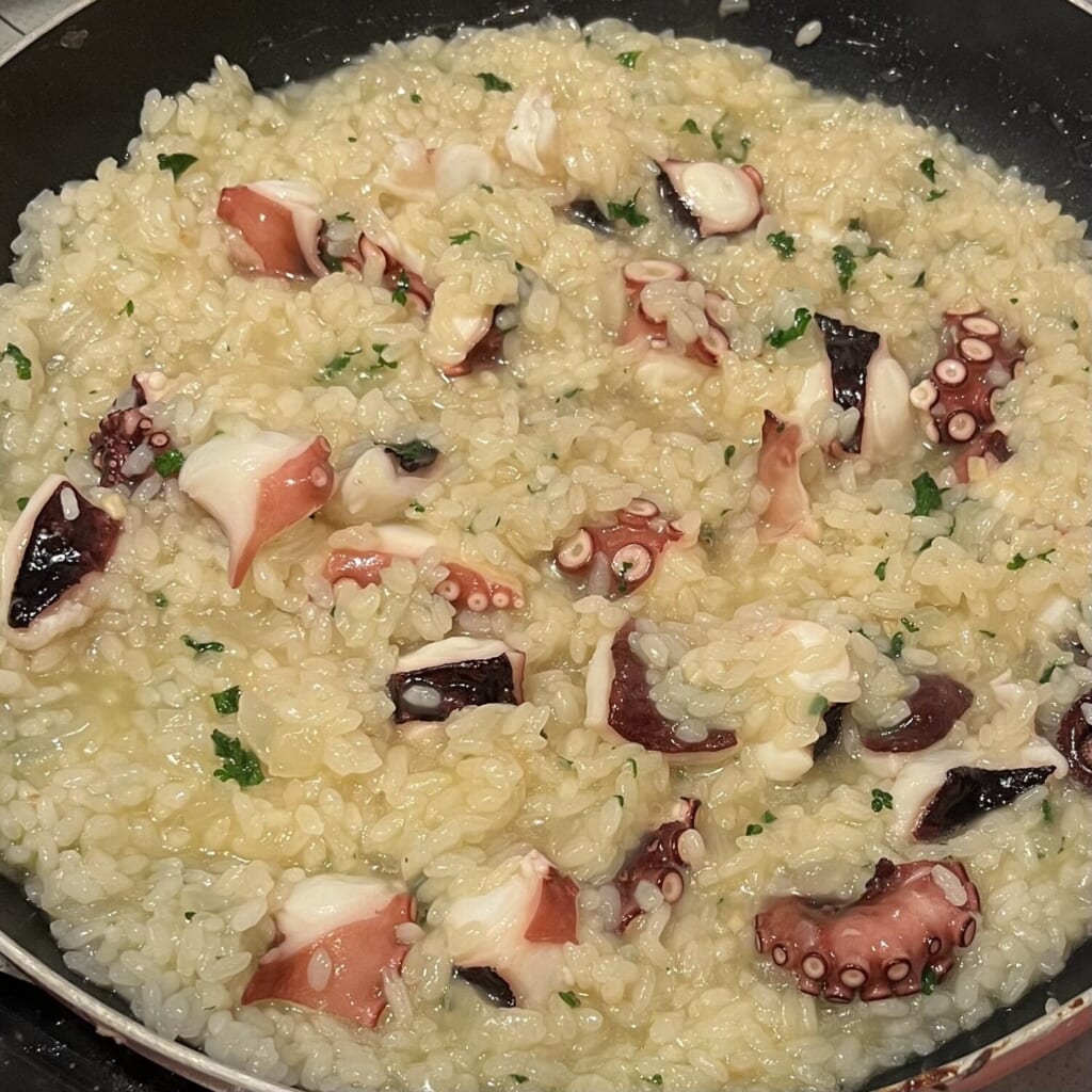 フライパンでタコのリゾットを作っている