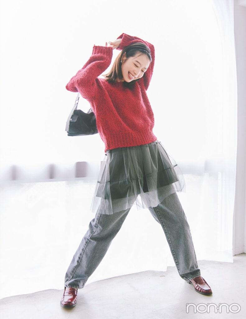 赤ニットとチュールキャミとグレーデニムパンツを合わせた赤ニットコーデの女性