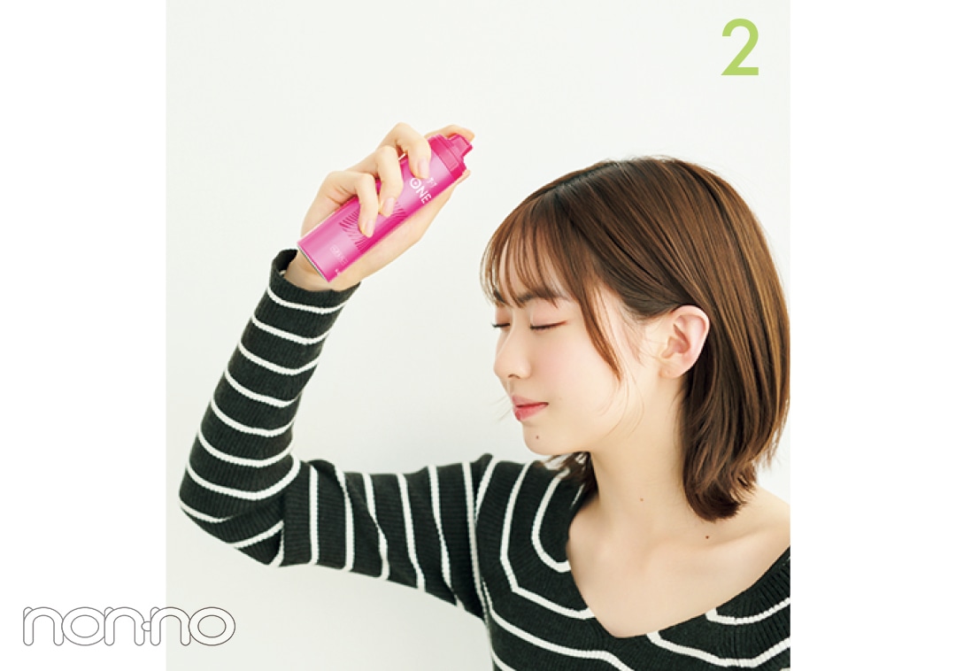 ヘアスプレーを前髪にかける女性