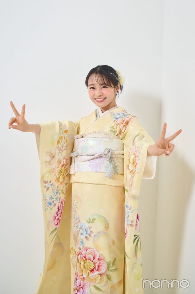 イエローの着物を着てピースする林芽亜里