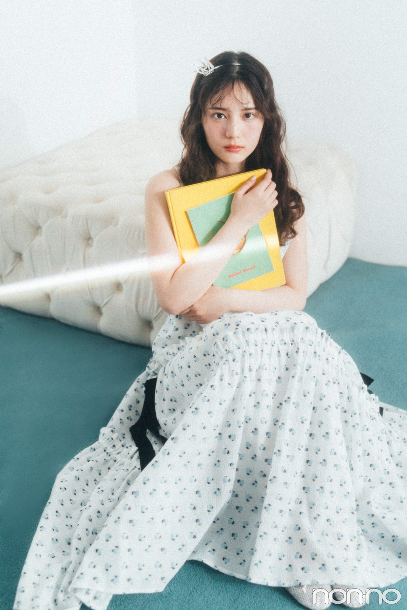 本を持ってソファにもたれる小坂菜緒