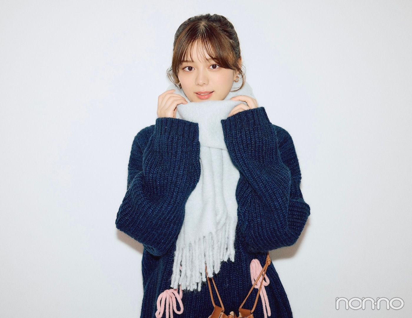 ニットの上にマフラーを巻いた紺野彩夏のバストアップカット