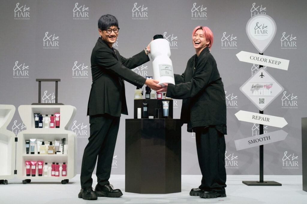 ボトル上の委任状をヘアメイクアップアーティストの河北裕介さんから手渡されるSnow Man佐久間大介さん