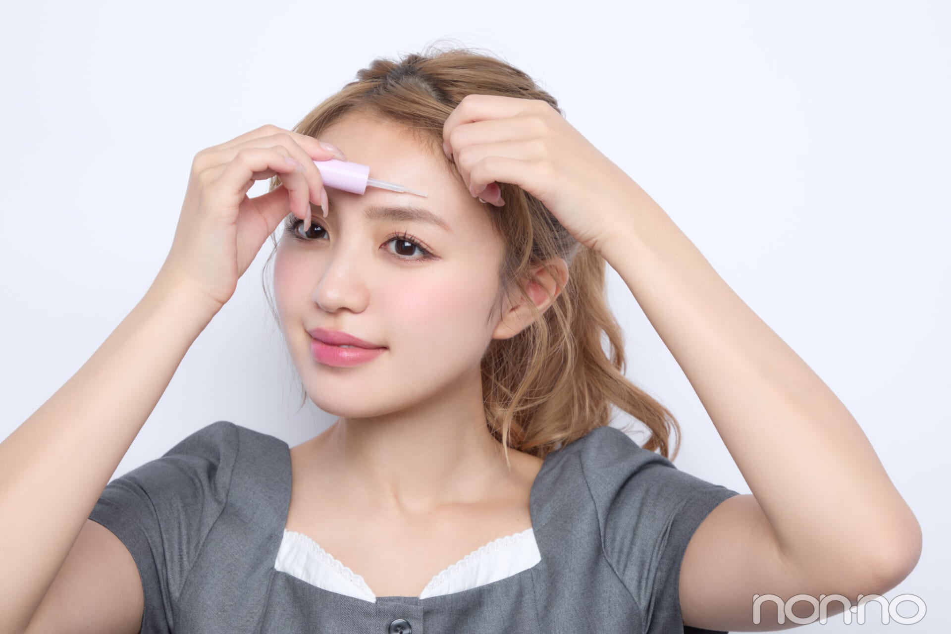 おでこにスタイリング剤をつけて前髪を固定する香音