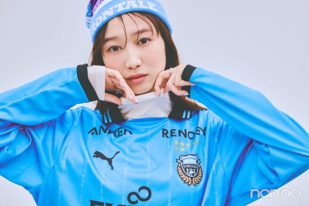 青いユニフォームの中にベージュのタートルネックを着た岡本夏美