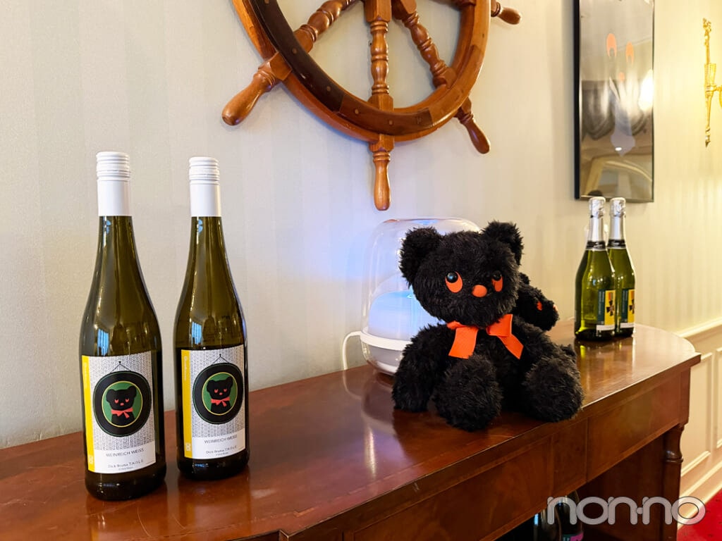 「ディック・ブルーナ テーブル」のオリジナルワインボトルやブラック・ベアが飾られたホテルラウンジ