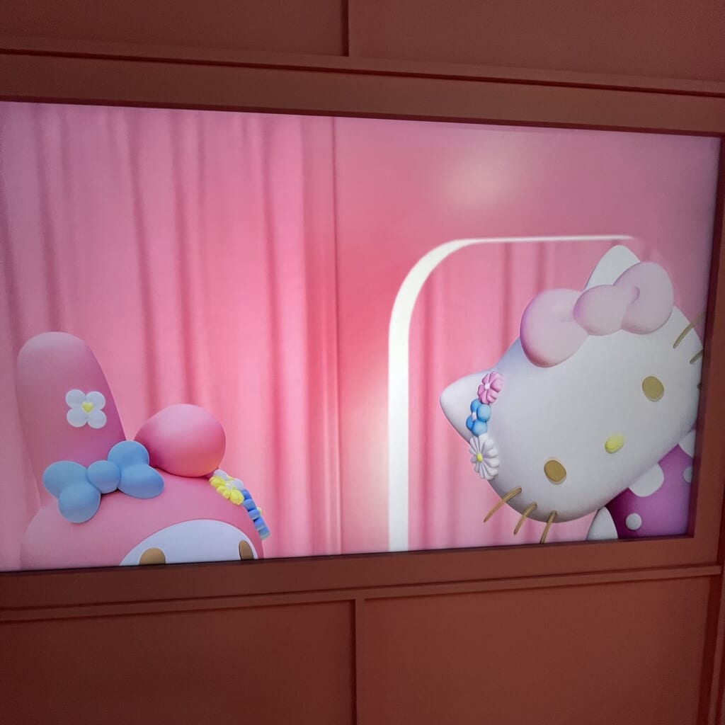 入口すぐの大きなモニターに映るハローキティとマイメロディの写真。