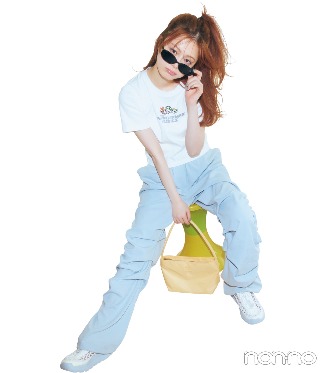 白のプリントTシャツ×スクランチパンツコーデで座っている女性