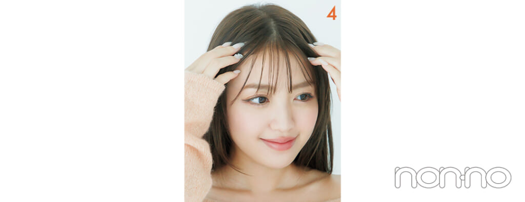 前髪にヘアワックスを手でつけている女性