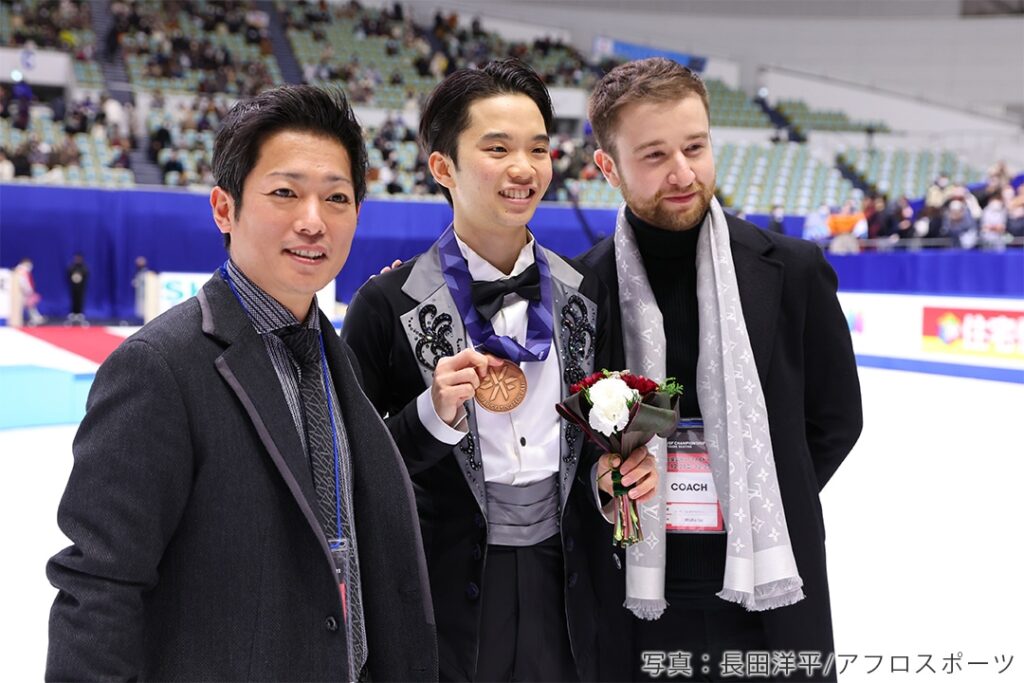 2022年全日本選手権表彰式での友野一希、平池コーチ、ミーシャ・ジーさん
