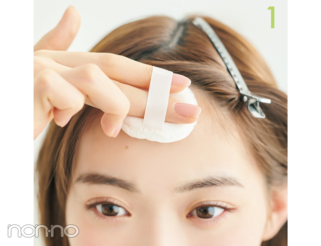 おでこにパフをあてる女性