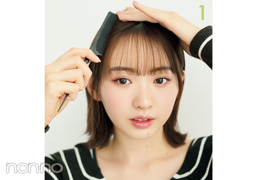 コームで前髪のサイドをとかす女性