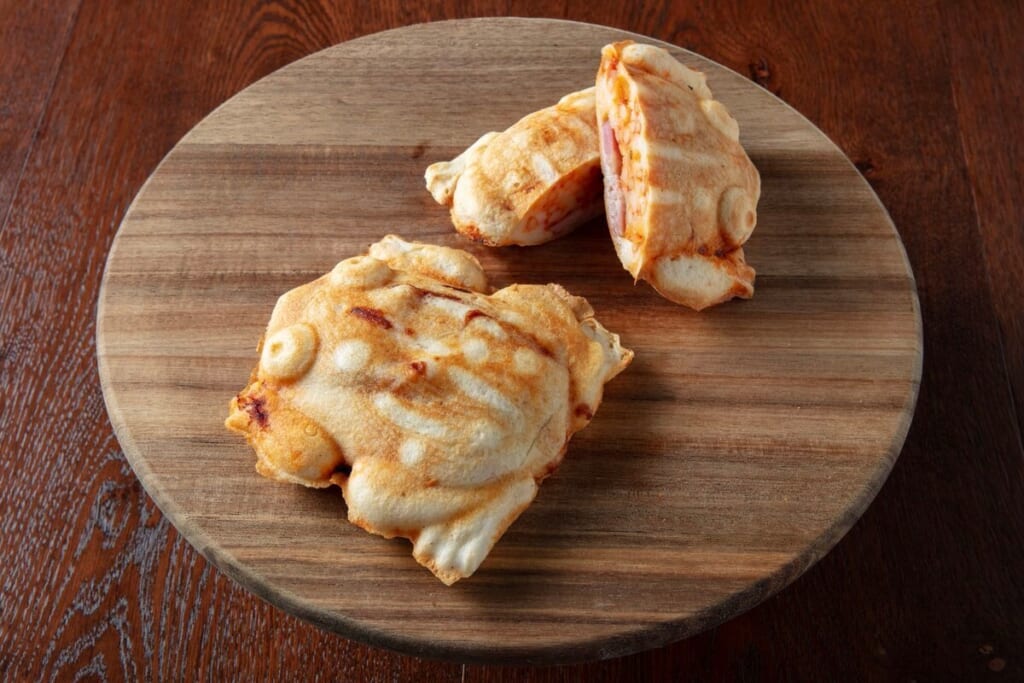 ジブリパーク「魔女の谷」内のレストラン「空飛ぶオーブン」外の屋台で販売されるカエル焼きの定番新味・ナポリタン