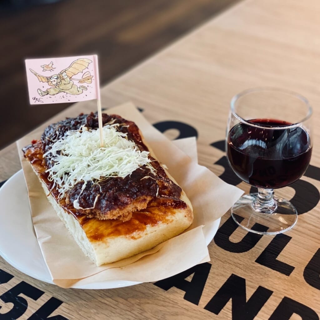 ジブリパーク「ジブリの大倉庫」内「カフェ 大陸横断飛行」のおすすめメニュー:味噌カツサンドと赤ワイン 紅の豚