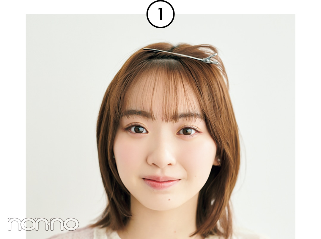 ヘアクリップで外側の前髪を上に留めている女性