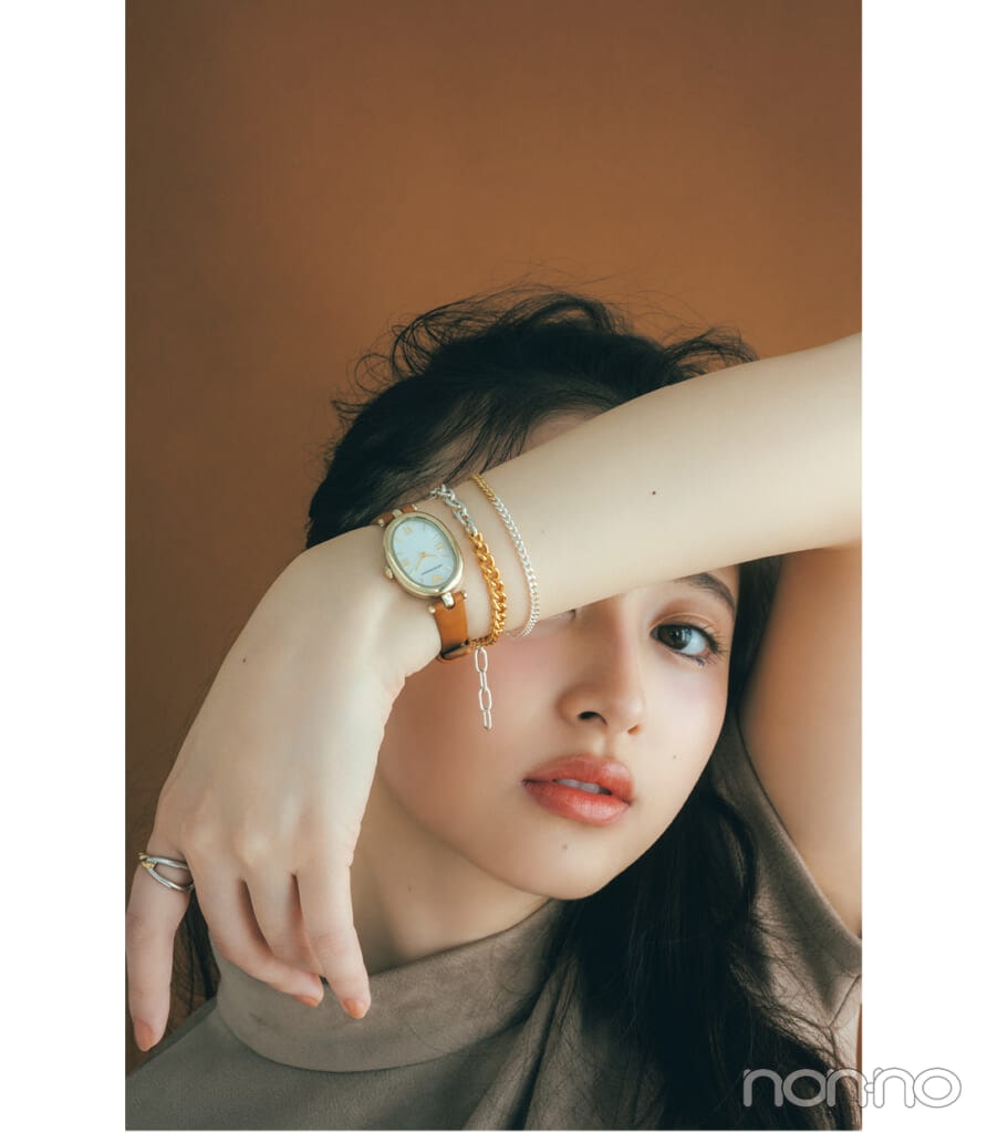 エンポリオ アルマーニのオーバル型フェイスのレザーベルト腕時計をつけた井上和