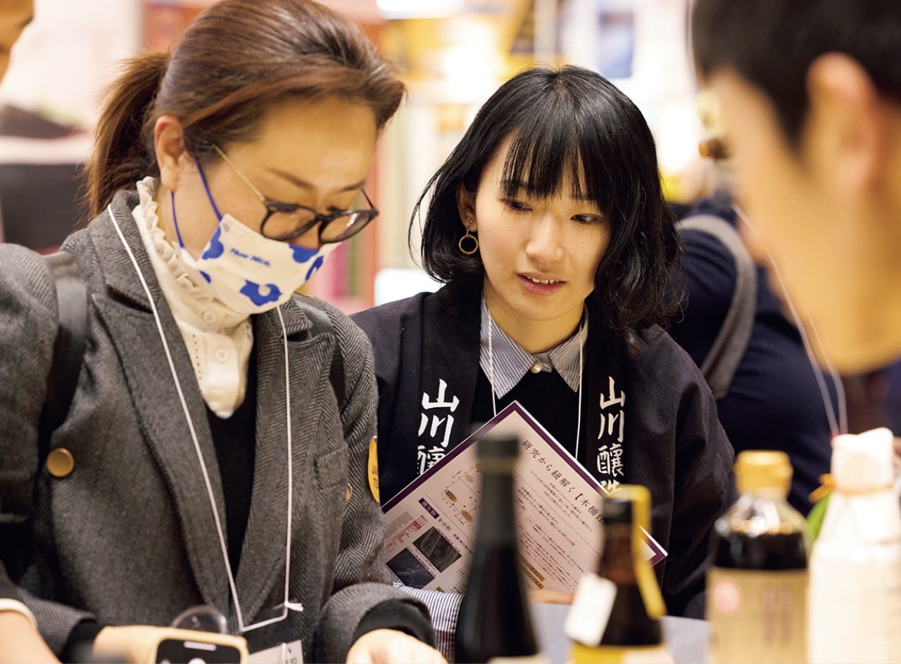 イベントで顧客に自社製品を説明する華奈子さん