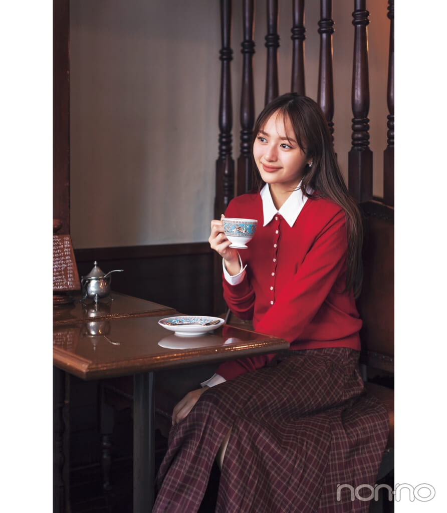 赤ニットカーディガンとシャツとロングスカートを合わせた赤ニットコーデの女性