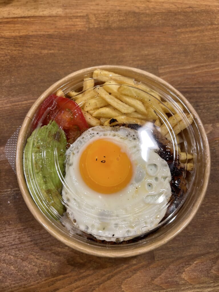 ポテトやアボカド、トマト、目玉焼きなどが入った器の写真