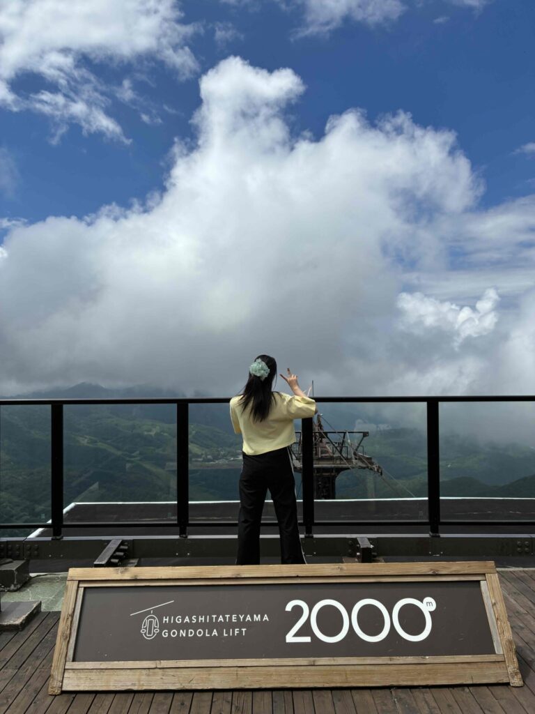 志賀高原ガーデンテラスにある2000メートルパネルと空と人の後ろ姿