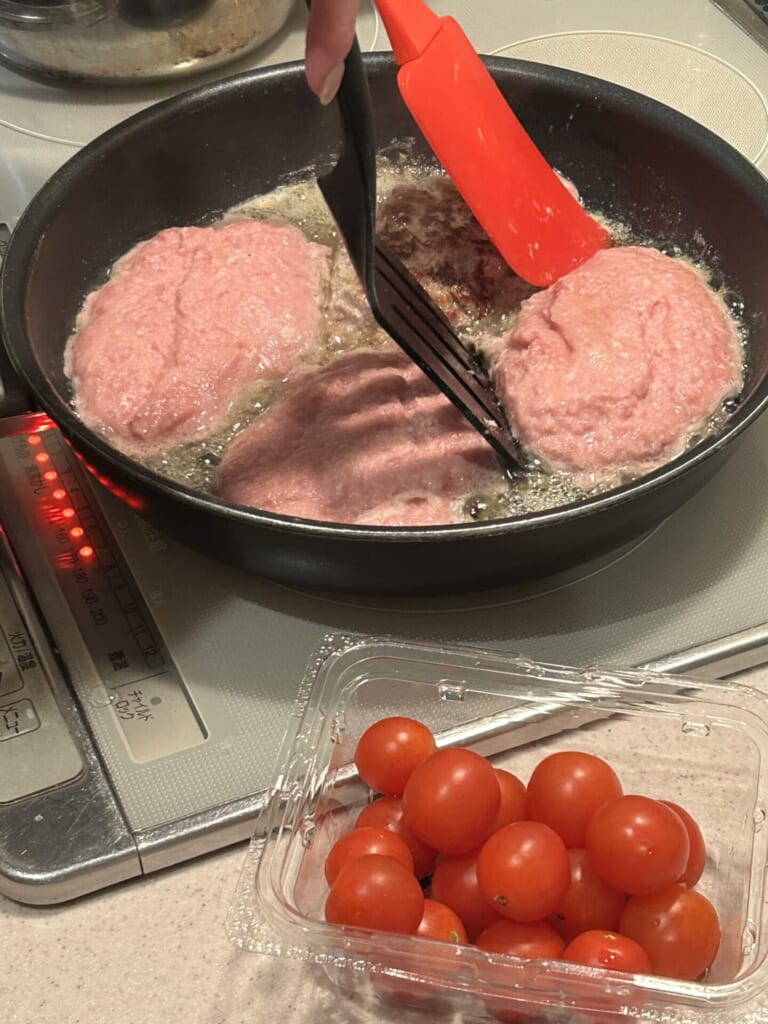 ハンバーグをヘラでひっくり返そうとしている画像