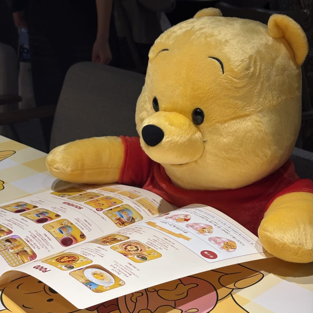 隣の席でメニューを眺めるプーさんのぬいぐるみ