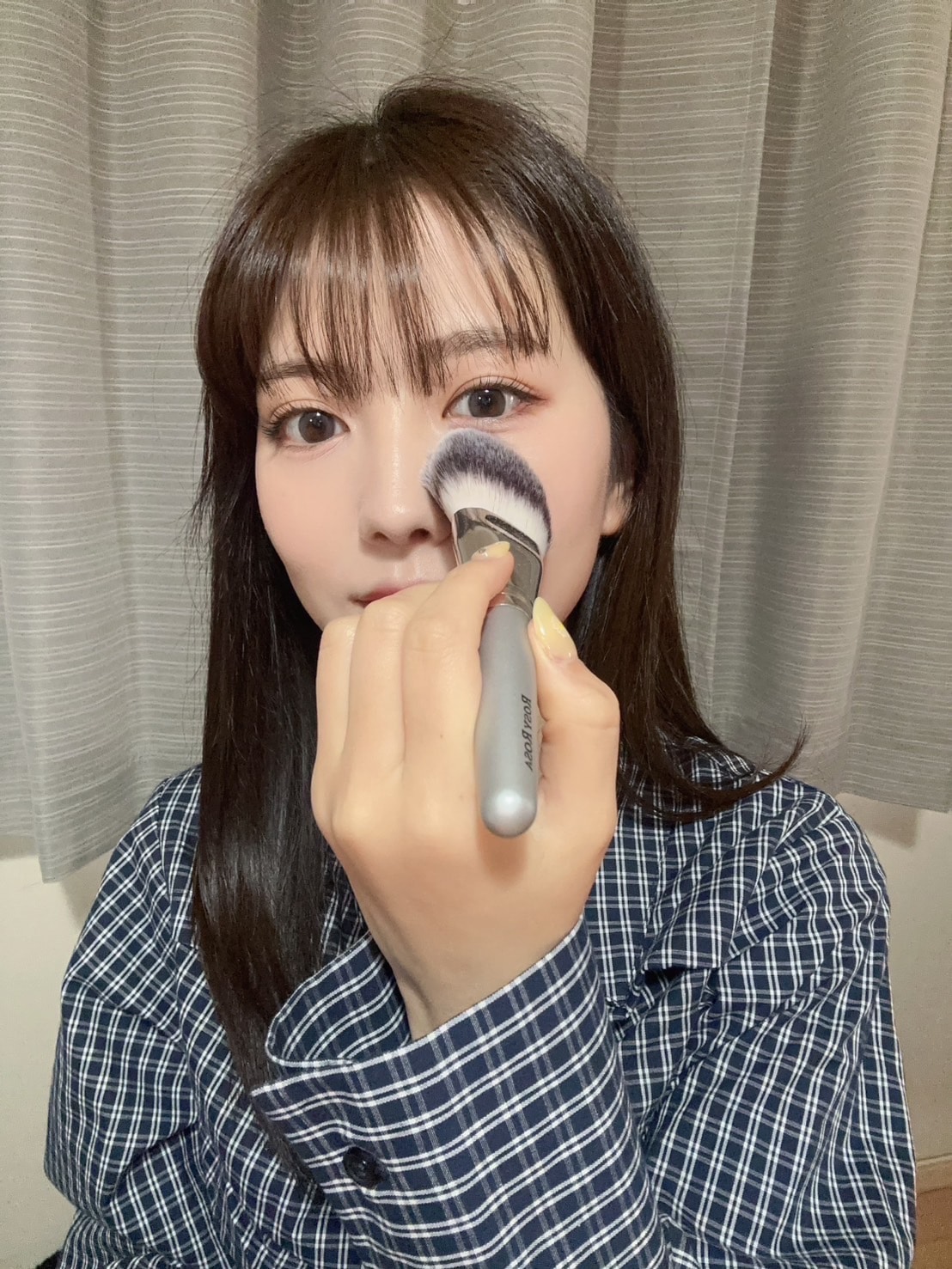 ロージーローザのパウダーファンブラシを目の下に当てるせきぐちりさ