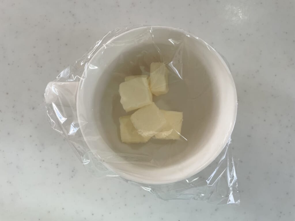 バターを入れた耐熱皿にラップをかける
