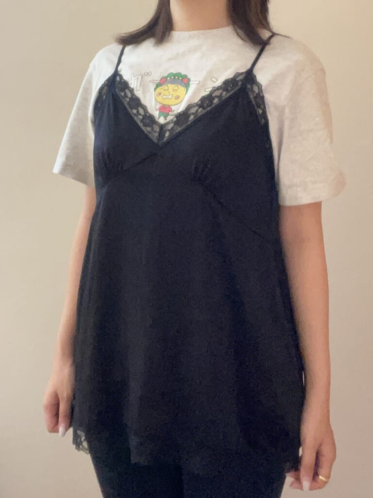 キャラクターデザインのTシャツの上からサテンキャミソール着用
