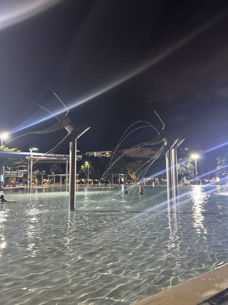 光が夜のプールに反射している。