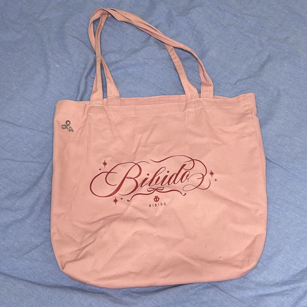 ピンク色のトートバッグの写真。真ん中に英語の文字が書いてある。