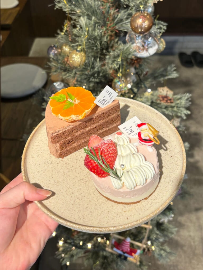 クリスマスツリーの前でケーキの写真を撮る