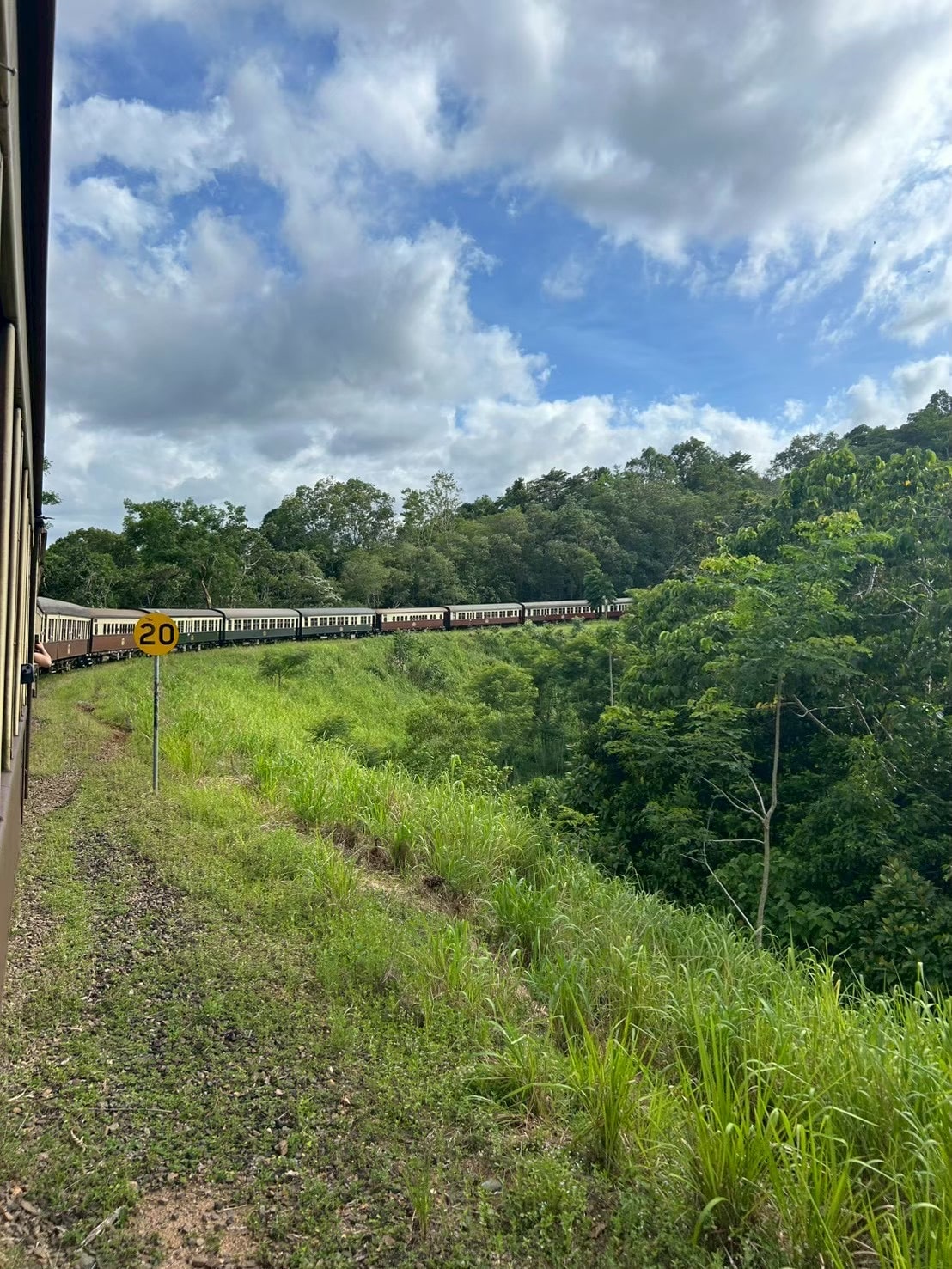 列車の中から見える写真。自然の中を列車が走る写真