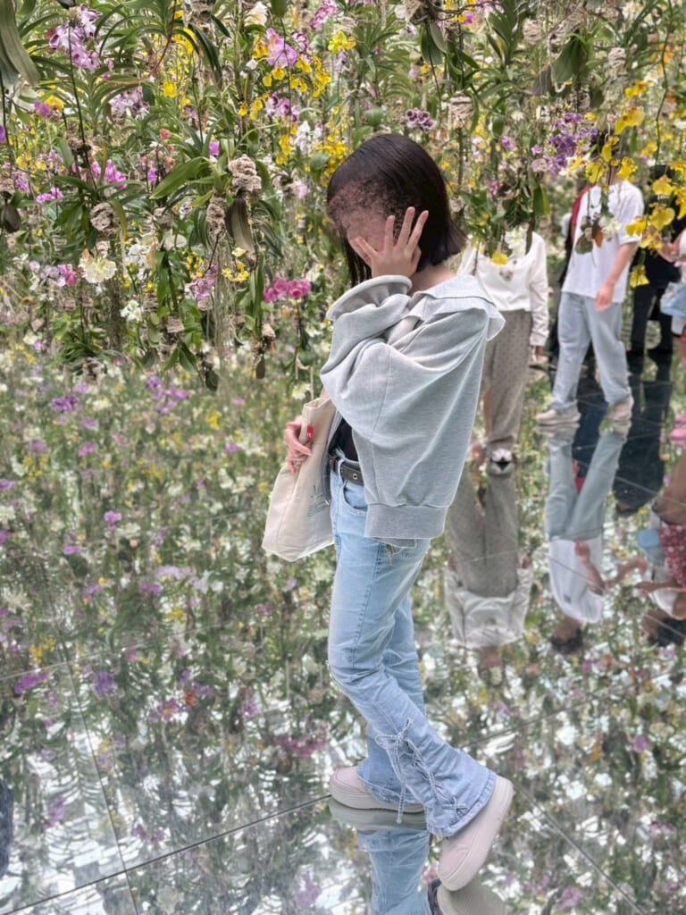 花を背景に女子が写っている