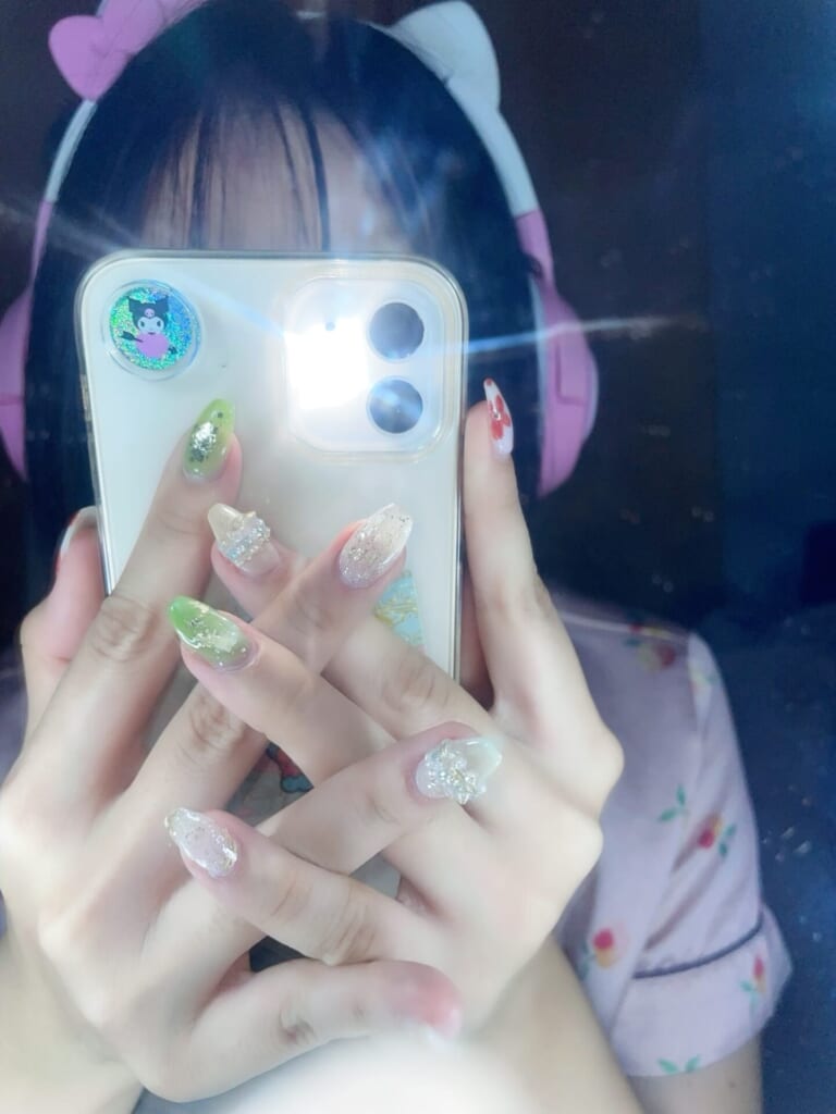 鏡越しにフラッシュ有にしてネイルを見せている