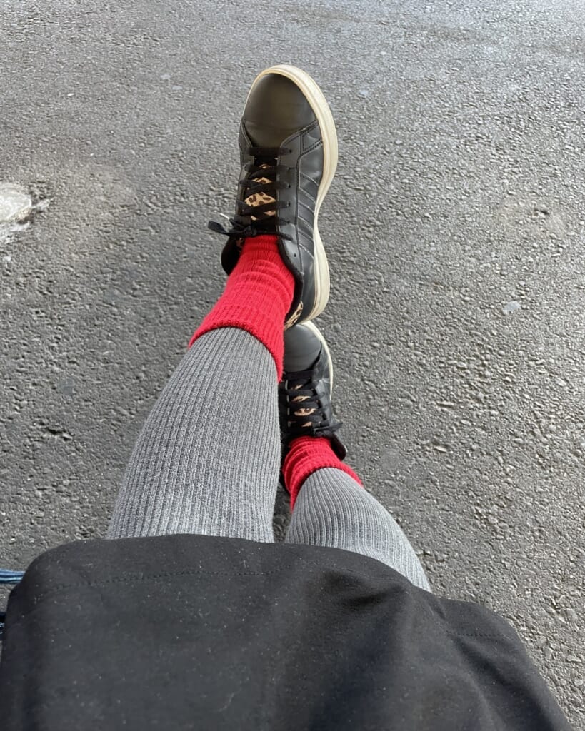 黒いスニーカー、赤い靴下、着用画像。