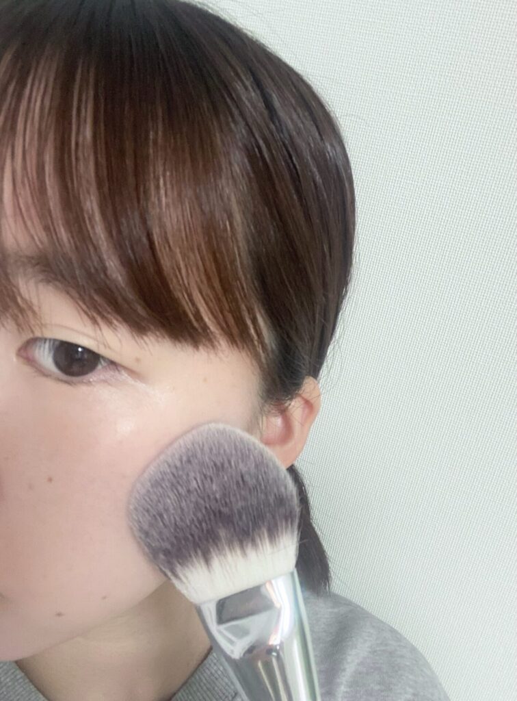 ROSY ROSAのパウダーファンブラシを使ってフェイスパウダーを肌にのせる
