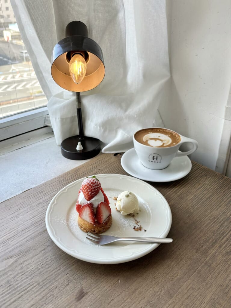 窓側のカウンター席でいちごのタルトとカフェラテ