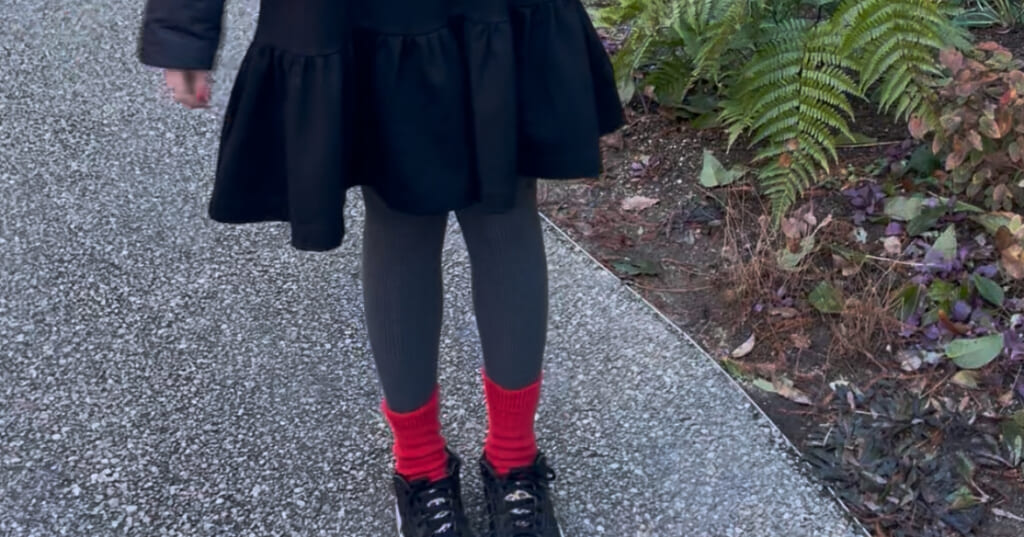 黒ワンピースとヒートテックニットリブタイツ、赤ソックスを合わせたコーデ