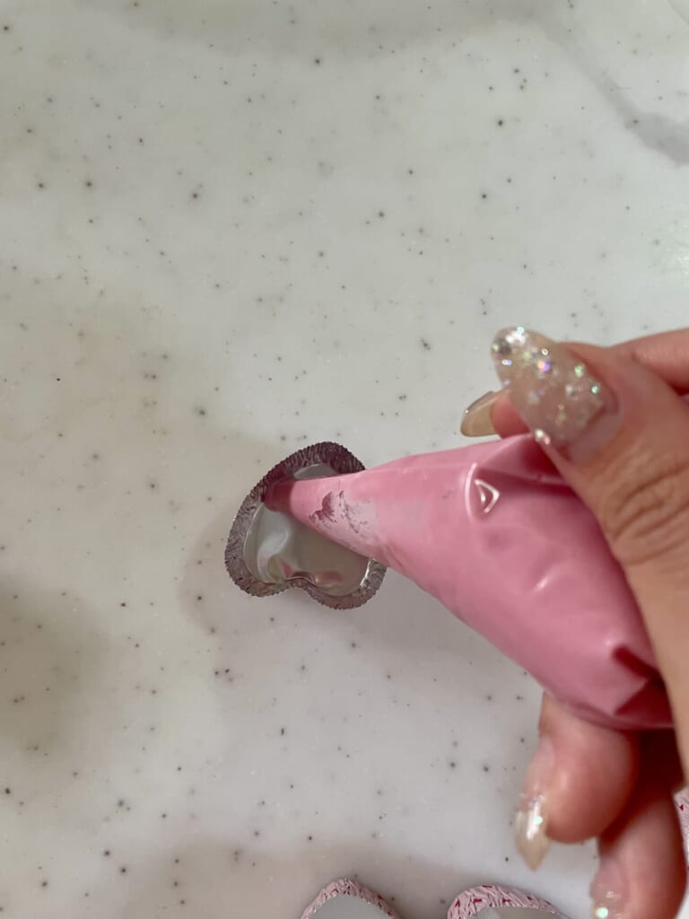 絞り袋から、アルミカップにチョコを入れている