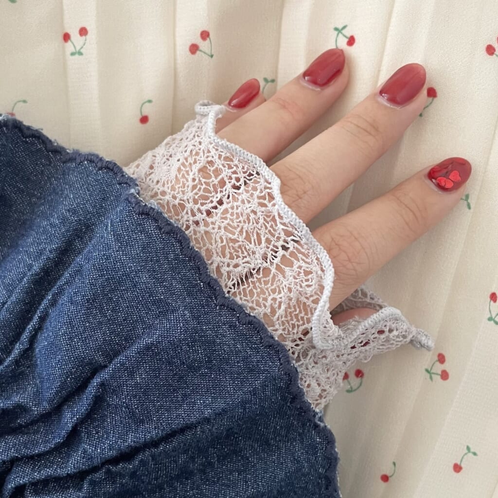 左手、赤マグネットネイルをサクランボ柄のスカートに合わせて