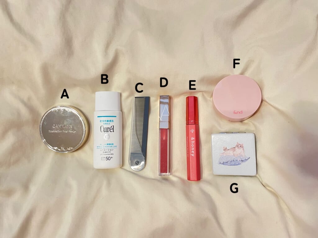 メイクとヘアの直しアイテムをAからGまで並べている