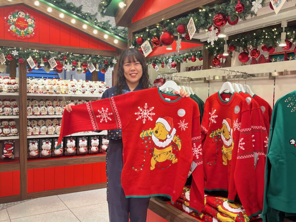 プーさんの光るセーターを持っている店員さんの写真